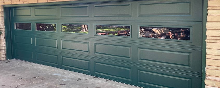 Example of a green garage door with a beige house