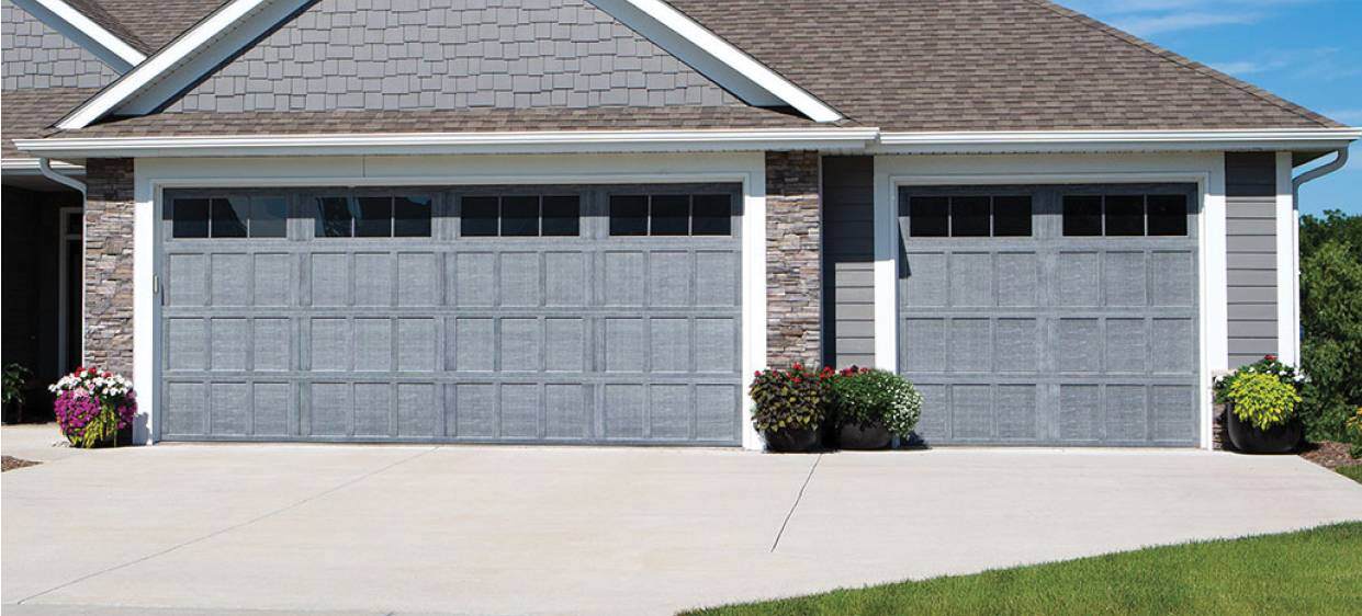 Gray ranch-style garage doors with flowers to the sides