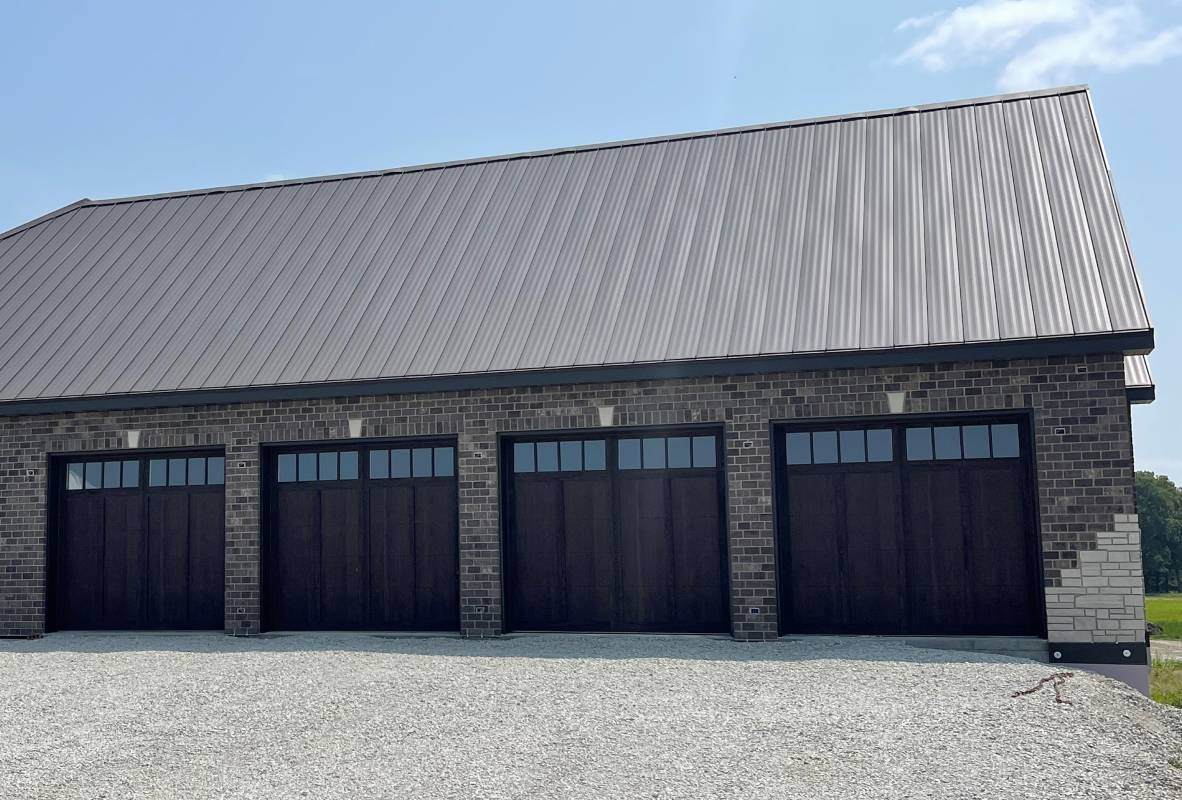 Overlay carriage house ranch-style garage doors in walnut