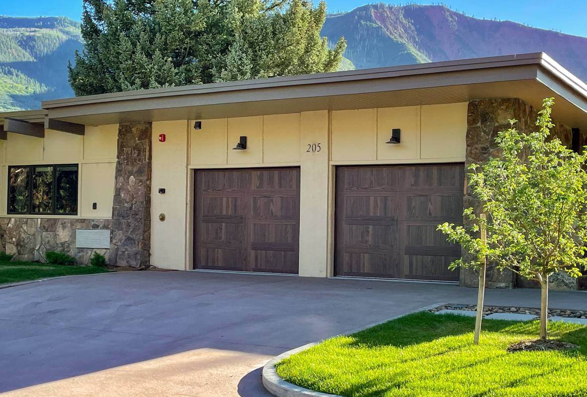 Stamped carriage house ranch-style garage doors in dark oak