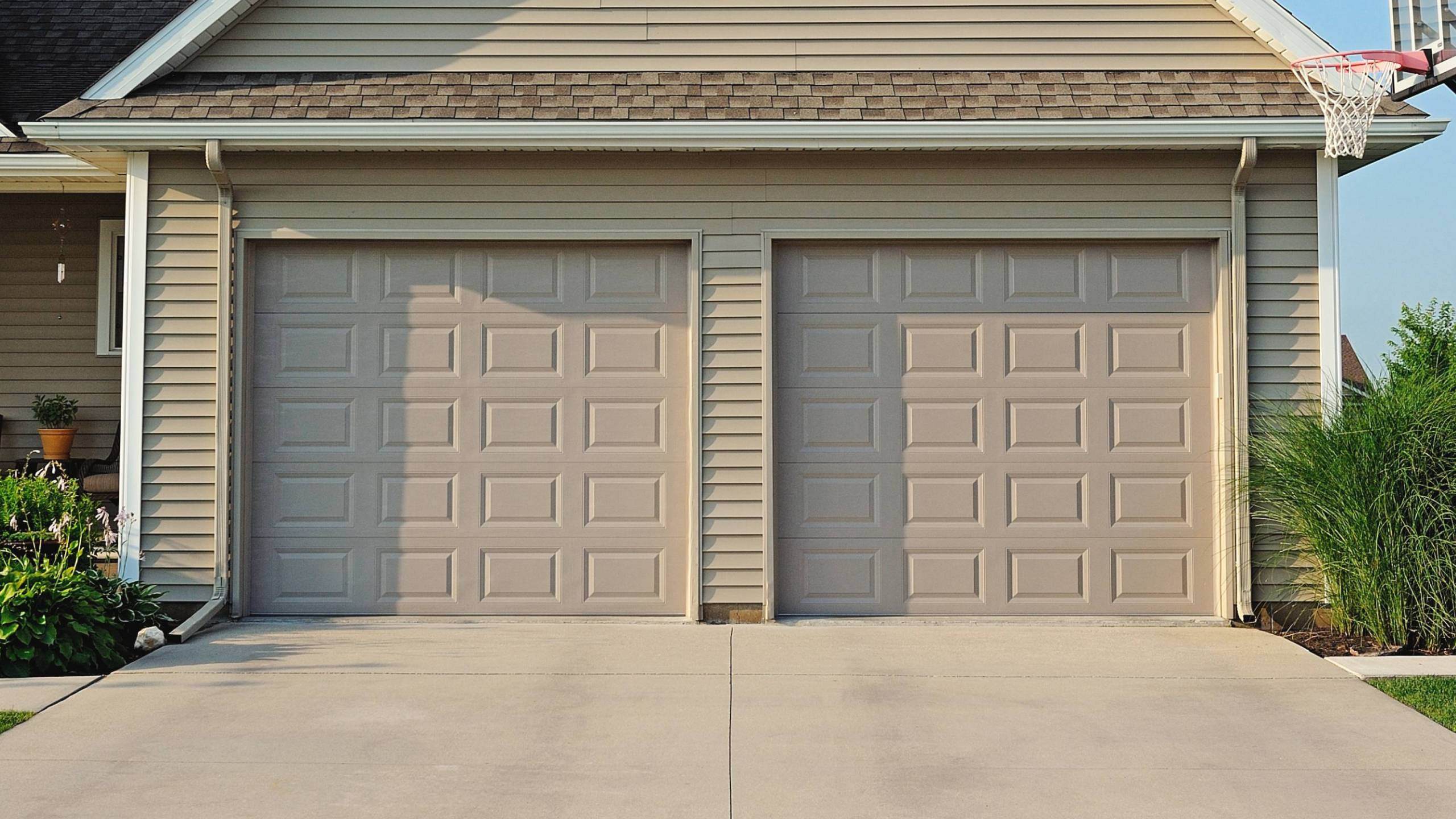 Raised panel garage door in sandstone with beige house