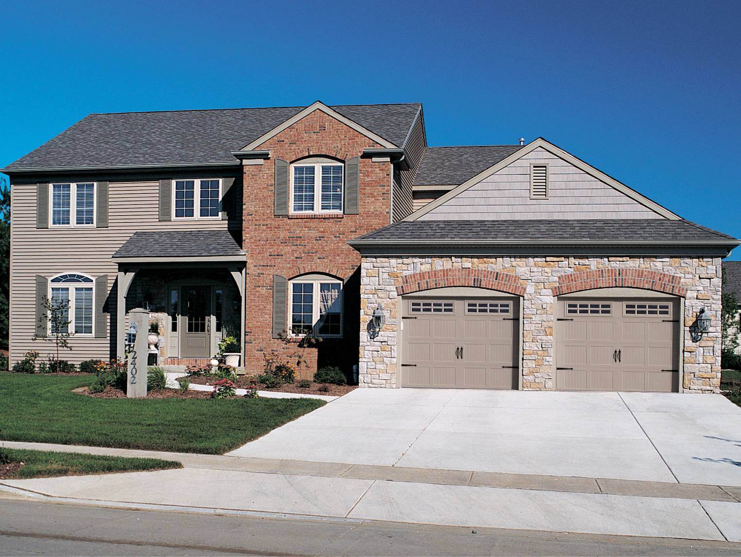 Stamped carriage house garage door in sandstone